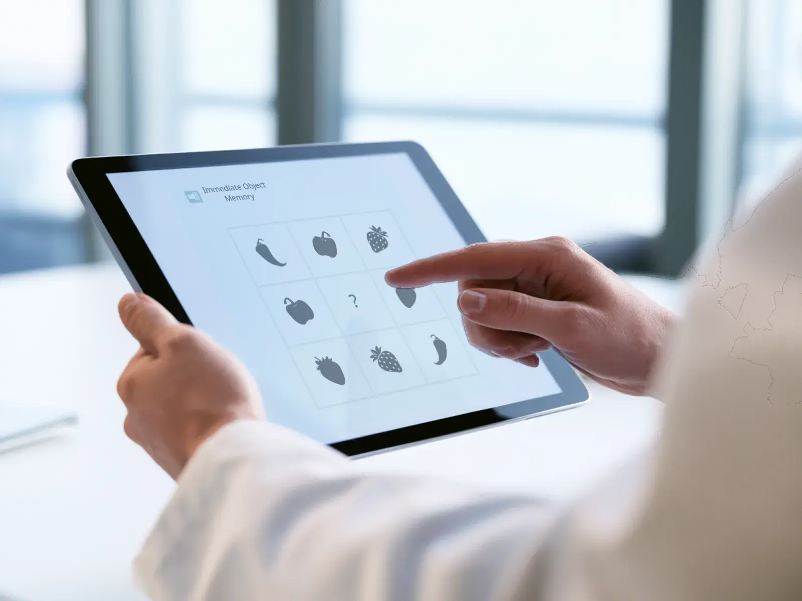A clinician completing an Immediate Object Memory task on a tablet