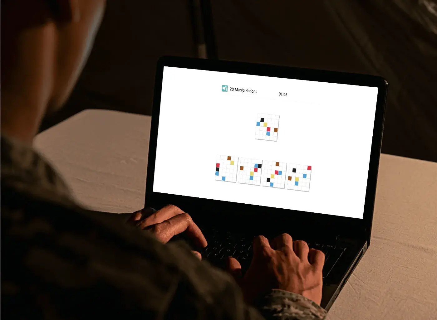 A service member completing a Cognitron 2D Manipulations task on a laptop