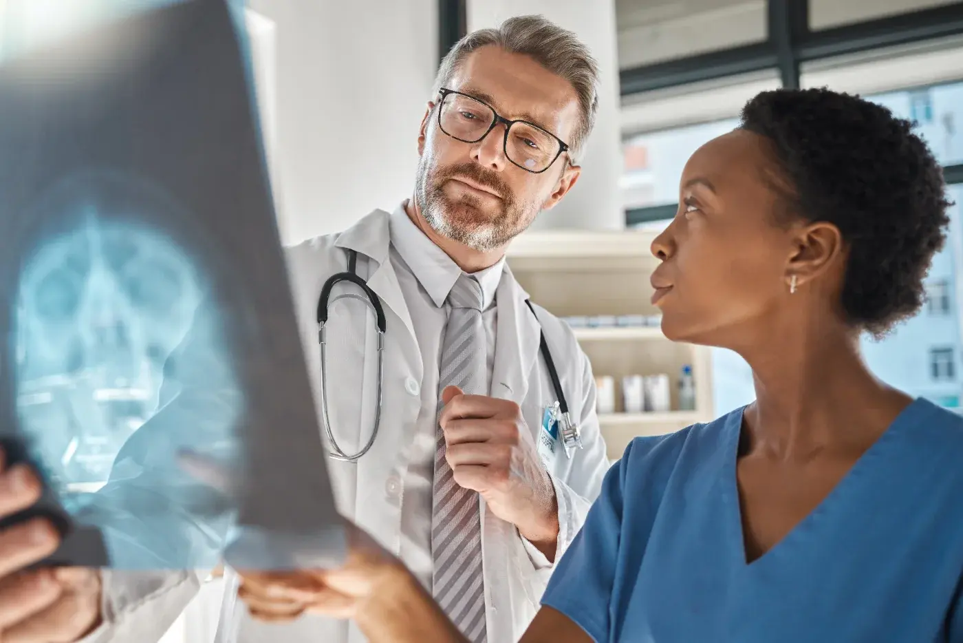 Two clinicians examining a brain scan together