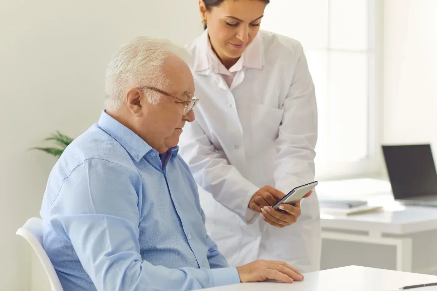 A clinician showing a patient a cognitive assessment on a phone