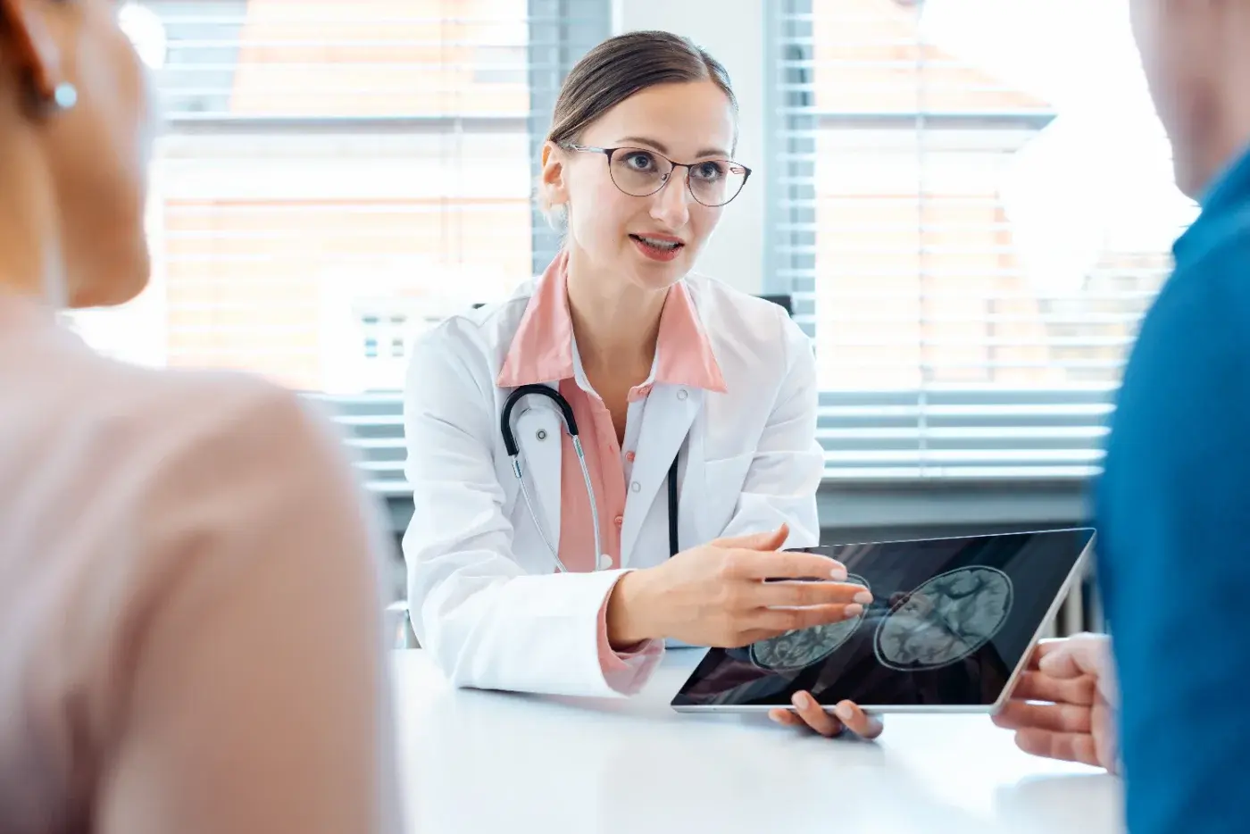 A clinician discussing brain scan results with patients on a tablet