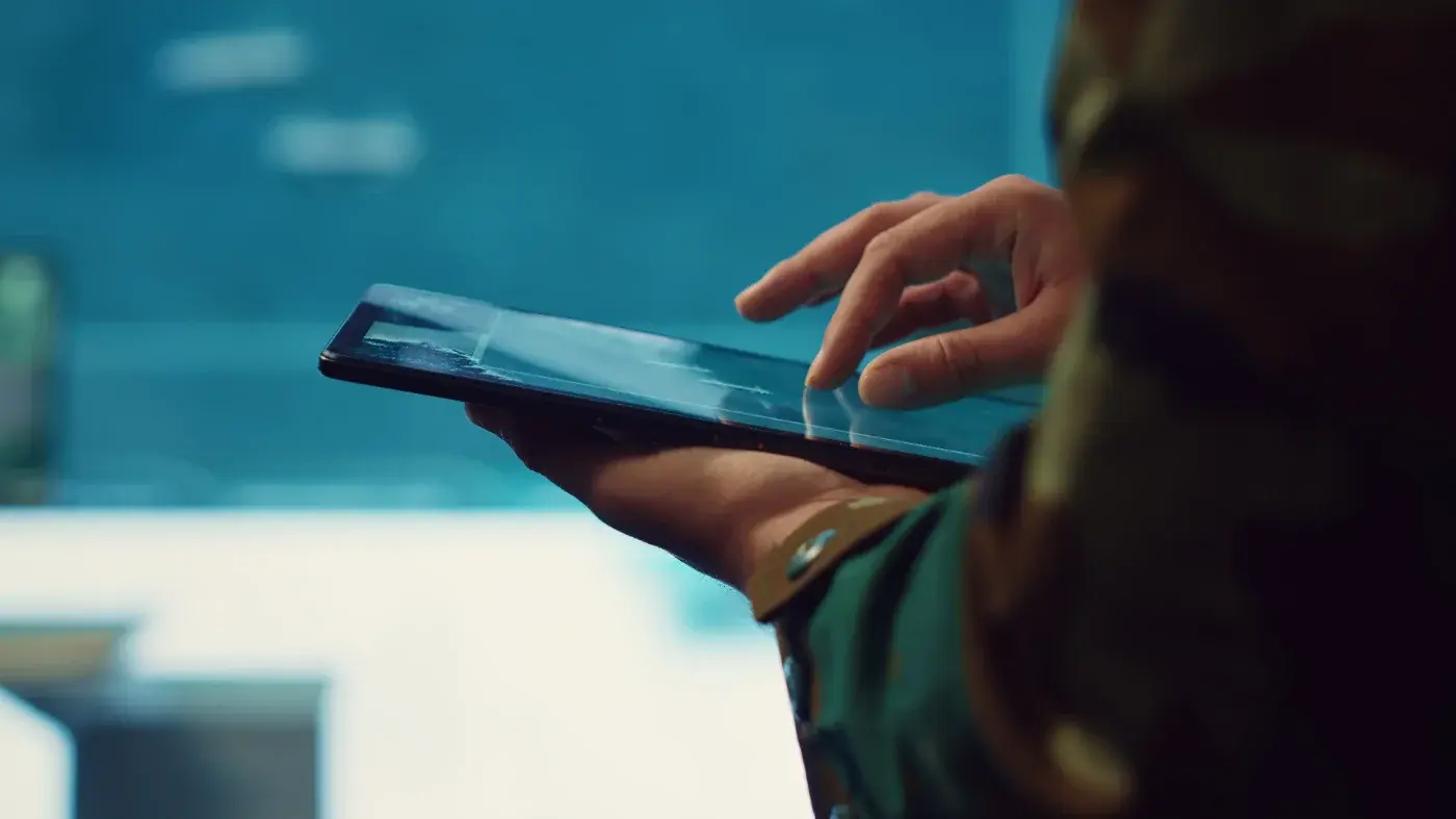 A service member using a tablet in an operations room