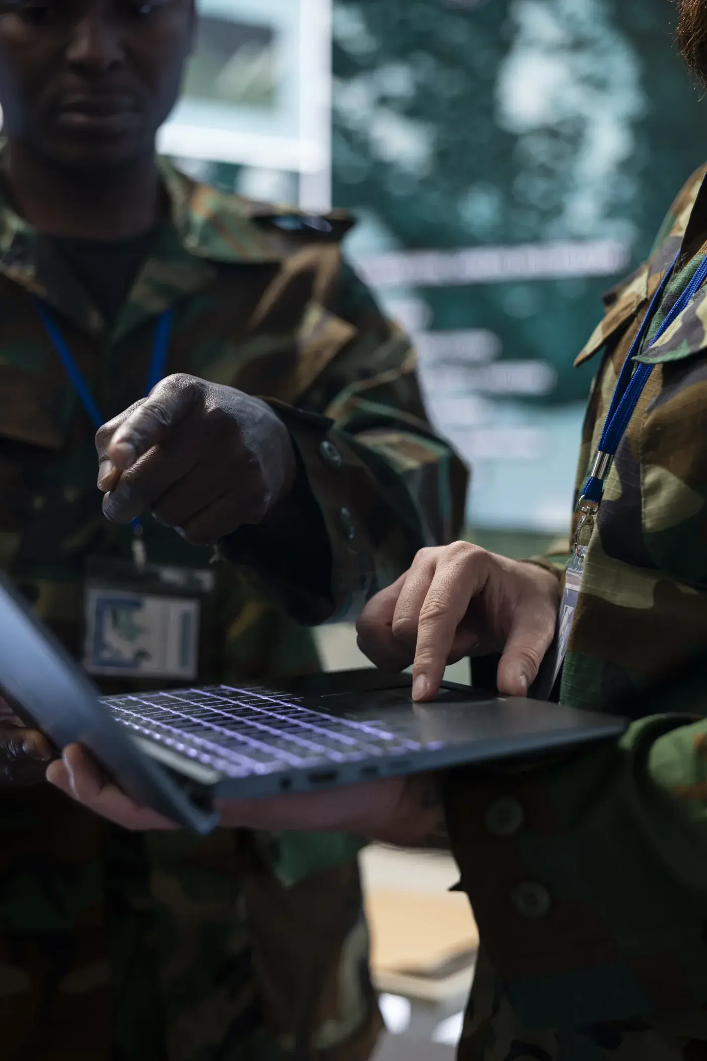 Service members reviewing data on a laptop in the field